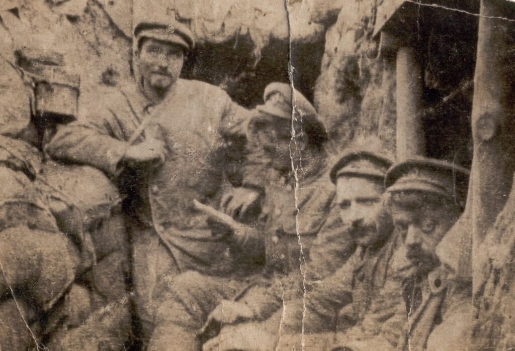 In the trench, France, early 1915, Bugler Hills centre reading a letter